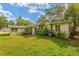 Home exterior with green backyard and some vegetation at 608 Se 31St Ter, Ocala, FL 34471