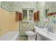 Retro bathroom featuring a bathtub, floral wallpaper, and vintage fixtures at 608 Se 31St Ter, Ocala, FL 34471