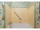 Functional bathtub with shower and safety bars, set against colorful wallpaper at 608 Se 31St Ter, Ocala, FL 34471