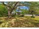 Home featuring a lush front yard shaded by mature trees at 608 Se 31St Ter, Ocala, FL 34471