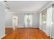 Living room with hardwood floors, white sheer curtains, and large windows letting in natural light at 608 Se 31St Ter, Ocala, FL 34471