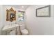 Quaint powder room features elegant pedestal sink and decorative mirror at 716 Se Wenona Ave, Ocala, FL 34471