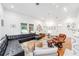 Spacious living room with black leather furniture, hardwood floors, and white walls at 716 Se Wenona Ave, Ocala, FL 34471