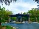 Stone community gate with covered entrance, a guardhouse, and mature trees creating a private setting at 7781 Sw 180Th Cir, Dunnellon, FL 34432