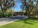 Community entrance featuring a gray stone entry surrounded by manicured landscaping and mature trees at 7781 Sw 180Th Cir, Dunnellon, FL 34432