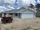 New construction home with a gray exterior, attached two-car garage, and simple landscaping at 7781 Sw 180Th Cir, Dunnellon, FL 34432