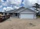 New construction home with a gray exterior, attached two-car garage, and simple landscaping at 7781 Sw 180Th Cir, Dunnellon, FL 34432