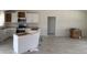 Unfinished kitchen with white cabinets, a stainless-steel oven, a microwave, and wood-look tile flooring at 7781 Sw 180Th Cir, Dunnellon, FL 34432