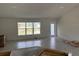 The spacious living room features wood-look tile flooring, a large window, and a glass-paned exterior door at 7781 Sw 180Th Cir, Dunnellon, FL 34432