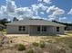 The back of the home features gray siding, a covered patio, and multiple windows for ample natural light at 7781 Sw 180Th Cir, Dunnellon, FL 34432