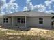 The back of the home features gray siding, a covered patio, and multiple windows for ample natural light at 7781 Sw 180Th Cir, Dunnellon, FL 34432