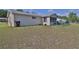Wide shot of the backyard showcases the grassy lawn and the home's exterior at 8443 Sw 109Th Place, Ocala, FL 34481