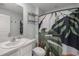 A well-lit bathroom features a vanity, a toilet, and a shower with a leaf-themed curtain at 8617 Triumph Cir, Wildwood, FL 34785
