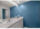 A bathroom with blue walls and a double sink vanity at 8617 Triumph Cir, Wildwood, FL 34785