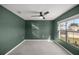 Neutral bedroom with carpet flooring, ceiling fan, and a large window at 8617 Triumph Cir, Wildwood, FL 34785