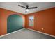 An eye-catching bedroom with a modern ceiling fan, unique wall decor, and a sunlit window at 8617 Triumph Cir, Wildwood, FL 34785