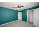 A bedroom with blue walls, a ceiling fan, carpet flooring and access to both the closet and the hallway at 8617 Triumph Cir, Wildwood, FL 34785