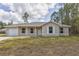 Charming single-story home featuring a front porch, attached garage, and a well-maintained lawn at 89 Fisher Way Crse, Ocklawaha, FL 32179