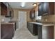 The kitchen has dark cabinets, light countertops, stainless steel appliances, and durable tile flooring at 89 Fisher Way Crse, Ocklawaha, FL 32179