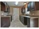 The kitchen has dark cabinets, light countertops, stainless steel appliances, and durable tile flooring at 89 Fisher Way Crse, Ocklawaha, FL 32179