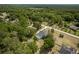 Aerial view of home with screened-in pool surrounded by lush landscaping and greenery at 8950 Se 17Th Ct, Ocala, FL 34480