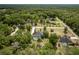 Overhead view of a home featuring a private screened pool, surrounded by verdant trees and lawn at 8950 Se 17Th Ct, Ocala, FL 34480