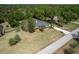Aerial view of a well maintained home with a pristine lawn and mature trees at 8950 Se 17Th Ct, Ocala, FL 34480