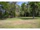 Lush backyard with mature trees providing shade and a peaceful setting, ideal for relaxation and outdoor enjoyment at 8950 Se 17Th Ct, Ocala, FL 34480