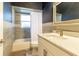 This bathroom features gray tile, a single sink, a bathtub and a mirror at 8950 Se 17Th Ct, Ocala, FL 34480