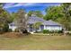 Charming single-story home featuring a well-manicured lawn, mature trees, and a classic architectural design at 8950 Se 17Th Ct, Ocala, FL 34480