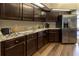 Kitchen showcasing granite counters, dark wood cabinetry, and stainless steel appliances at 8950 Se 17Th Ct, Ocala, FL 34480