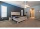 This main bedroom features carpet, a ceiling fan and a decorative accent wall at 8950 Se 17Th Ct, Ocala, FL 34480