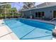 The screened pool is complemented by a patio area perfect for grilling and outdoor dining near the home at 8950 Se 17Th Ct, Ocala, FL 34480