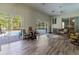 Enclosed sunroom with pool access, casual seating, and wood-look floors at 8950 Se 17Th Ct, Ocala, FL 34480