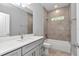 Modern bathroom featuring a gray vanity with white countertop and a tiled shower/tub with window at 9405 Se 159Th Ln, Summerfield, FL 34491