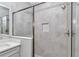 Tiled walk-in shower featuring glass doors, a rainfall shower head, and a built-in niche at 9405 Se 159Th Ln, Summerfield, FL 34491