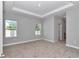 Bright bedroom featuring neutral carpet, a tray ceiling, and two bright windows at 9405 Se 159Th Ln, Summerfield, FL 34491