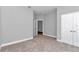 Neutral-toned bedroom with multiple doorways and neutral carpet and base trim at 9405 Se 159Th Ln, Summerfield, FL 34491