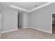 Bright bedroom featuring neutral walls, plush carpeting, and an inviting tray ceiling detail at 9405 Se 159Th Ln, Summerfield, FL 34491