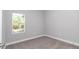 A simple bedroom features neutral carpet, base trim, and a bright window view at 9405 Se 159Th Ln, Summerfield, FL 34491