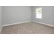 Empty bedroom with neutral carpet, a window offering natural light, and baseboard trim at 9405 Se 159Th Ln, Summerfield, FL 34491
