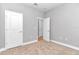 A bright bedroom featuring neutral carpet, base trim, and multiple white doors at 9405 Se 159Th Ln, Summerfield, FL 34491