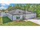 Well-manicured lawn highlights this single-story home with a modern design and attached two-car garage at 9405 Se 159Th Ln, Summerfield, FL 34491