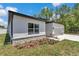 Newly built house showing the side facade and corner of the garage with manicured landscaping at 9405 Se 159Th Ln, Summerfield, FL 34491