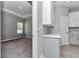 Hallway featuring gray cabinetry and a view into a bright bedroom with a tray ceiling at 9405 Se 159Th Ln, Summerfield, FL 34491