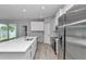 Modern kitchen featuring a large center island, white cabinets, and stainless steel appliances at 9405 Se 159Th Ln, Summerfield, FL 34491