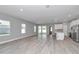 Bright, airy living room with light hardwood floors, large windows, and an open layout with a kitchen area at 9405 Se 159Th Ln, Summerfield, FL 34491