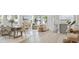 Open-concept living space with modern decor and ample natural light, seamlessly connecting dining, kitchen, and living areas at 9405 Se 159Th Ln, Summerfield, FL 34491