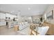 Open-concept living room featuring modern furniture, light hardwood floors, and a view of the kitchen at 9405 Se 159Th Ln, Summerfield, FL 34491