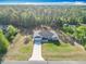 An aerial view highlighting the home's setting, spacious lot, and proximity to lush woods at 9525 Sw 200 Ct, Dunnellon, FL 34431